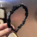 Détail d'un serre-tête en satin plissé noir orné de strass ovales et de losanges étincelants - Style Strass Noir (A5-104)