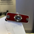 Macro detail of vintage red velvet hair clip with sparkling rhinestones and center jewel - Red Hair Clip