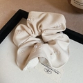 Detailed macro of ivory scrunchie with floral embroidery and delicate pearls texture - White Scrunchie