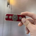 Dettaglio del fermaglio in velluto rosso con gemma grigia e contorno di cristalli - Stile Velluto Rosso (A5-110)