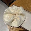 Détail d'un chouchou en organza crème avec perles et strass dans un coffret à bijoux - Blanc Cassé