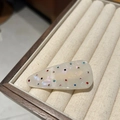 Detail bunter Straßsteine auf perlweißem Acetat-Haarclip auf einem Holz-Schmucktablett - Gebrochenes Weiß