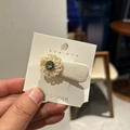 Close-up of a cream fabric duckbill clip featuring a beaded flower and a sparkling rhinestone - Beige