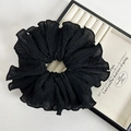 Detail of elegant black pleated chiffon scrunchie with layered ruffles in a jewelry box - Black Hair Tie