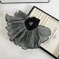 Detailed view of black and white gingham oversized ruffle scrunchie on cream jewelry box - Gray Streamer