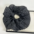 Detalle de un coletero grande con lunares blancos y negros en bandeja blanca - Lunar Negro
