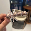 Detalle del pasador de perlas champán con lazo rosa y diamantes de imitación - Rosa