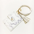 Detail eines Kartenhalters mit Marmormuster, O-Ring Armband und goldener Quaste - Marmor