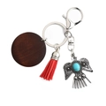 Bohemian silver eagle keychain with turquoise stone and red tassel on white background - Red