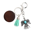 Vintage eagle keychain with mint green tassel and turquoise inlay on white background - Green
