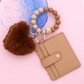 Detail of beaded silicone wristlet with plush heart charm and wave-edge leather card holder - Khaki