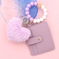 Detail view of purple silicone bead wristlet with leather card wallet and heart pompom - Purple