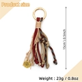 Dettaglio del portachiavi boho con nappa in pelle intrecciata e ciondolo girasole - Cachi Girasole