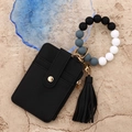 Macro shot of black pebbled leather wallet with beaded wristlet and gold hardware - Black