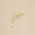 Spilla classica a forma di spiga di grano dorata con zirconi gialli su sfondo beige - Zirconia Champagne