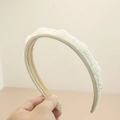 Detailed view of beige satin headband with crystal bead clusters and non-slip lining - Off White
