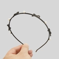 Elegant thin black headband featuring small white pearls and chic bow accents - Black