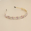 Détail de strass en cristal rose et blanc sur un serre-tête en métal doré élégant - Strass Rose