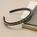 Dettaglio di un cerchietto vintage con cristalli neri e montature in metallo dorato - Zircone Nero