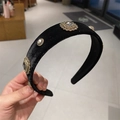 Detail of a wide black velvet headband with vintage rhinestones in a retail shop setting - Floral Jewel Embellished / Black Style A