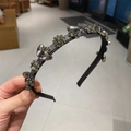 Detailed macro view of vintage luxury grey headband with sparkling crystal leaf patterns - Black Base Gun Black