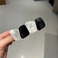 Dettaglio del fermaglio in acetato bianco e nero con design geometrico moderno - Nero e Bianco