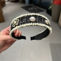 Détail d'un serre-tête en tweed avec perles fantaisie et fleur de camélia dorée - Noir