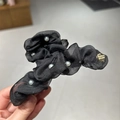 Dettaglio ravvicinato della pinza per capelli in rete nera con perle e targhetta dorata - Nero