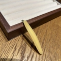 Gros plan d'une barrette à cheveux longue en acétate crème sur un plateau à bijoux en bois chic - Jaune