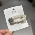Primer plano de horquilla de perlas con diamante de imitación en tarjeta blanca - Estilo Strass