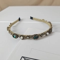 Detail of baroque pearl headband with green crystals and gold metal texture - Green Oval Gemstone