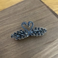 Dettaglio macro della molletta per capelli a cigno con cristalli blu su legno - Blu Reale