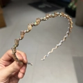 Détail du serre-tête ondulé avec cristaux champagne et strass colorés brillants - Champagne
