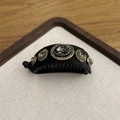Dettaglio del fermaglio a banana in velluto nero con un grande cristallo grigio - Zirconia Ovale