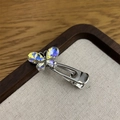 Macro detail of a silver alloy butterfly hair clip with iridescent crystals and duckbill clip - Butterfly White B