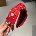 Vue détaillée du bandeau rouge noué avec des cœurs violets et des strass étincelants - Rouge