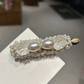 Macro detail showing vintage baroque pearls and delicate mother-of-pearl wing on hair clip - White