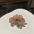 Vista posteriore della spilla a fiore rosa con ago dorato e dettaglio foglia blu - Spilla
