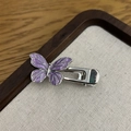 Detailaufnahme einer lila Schmetterlingshaarklammer mit Marmortextur auf Holztablett - Schmetterling Lila B