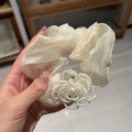 Dettaglio dell'elastico in organza color crema con grande fiore di camelia in perle bianche - Bianco Sporco