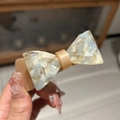Détail de la pince à cheveux noeud en acétate montrant la texture nacrée et le ressort - Marbre Rose et Bleu
