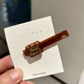 Detail of amber brown acetate hair clip with square yellow crystal and tortoise pattern - Brown