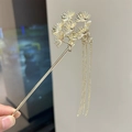 Close-up of golden pine needle hair stick with long tassel chains for Hanfu styling - Gold