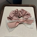 Elegante elastico in raso rosa con fiocco in pizzo e perle su vassoio beige - Rosa