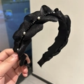 Dettaglio di cerchietto in tessuto nero a pieghe con perle e cristalli neri lucidi - Stile Cristallo con Volant