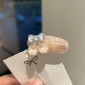 Detail of a handmade pink acetate hair clip with blue bow and gold lettering - Grey Pink Cherry