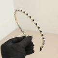 Détail d'un serre-tête doré élégant avec perles blanches et perles noires facettées chic - Cristal Noir
