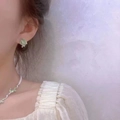 Detail showing elegant cat eye stone necklace with pearl chain worn by a model - Stud Earrings