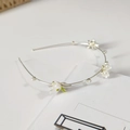 Primer plano de elegante diadema floral con pétalos de lirio blanco y perlas - Estilo Lirio de los Valles
