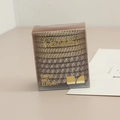 Macro-opname van elastische haarelastiekjes met glittertextuur in een heldere doos - Doosverpakking / Goud/Paars